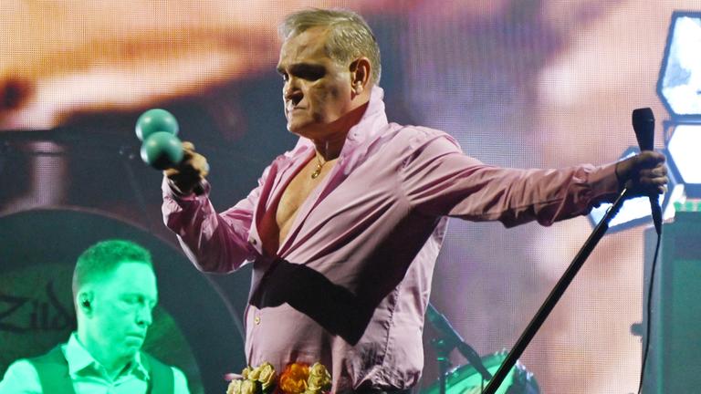 Musiker Morrissey steht auf einer Bühne und performt einen Song