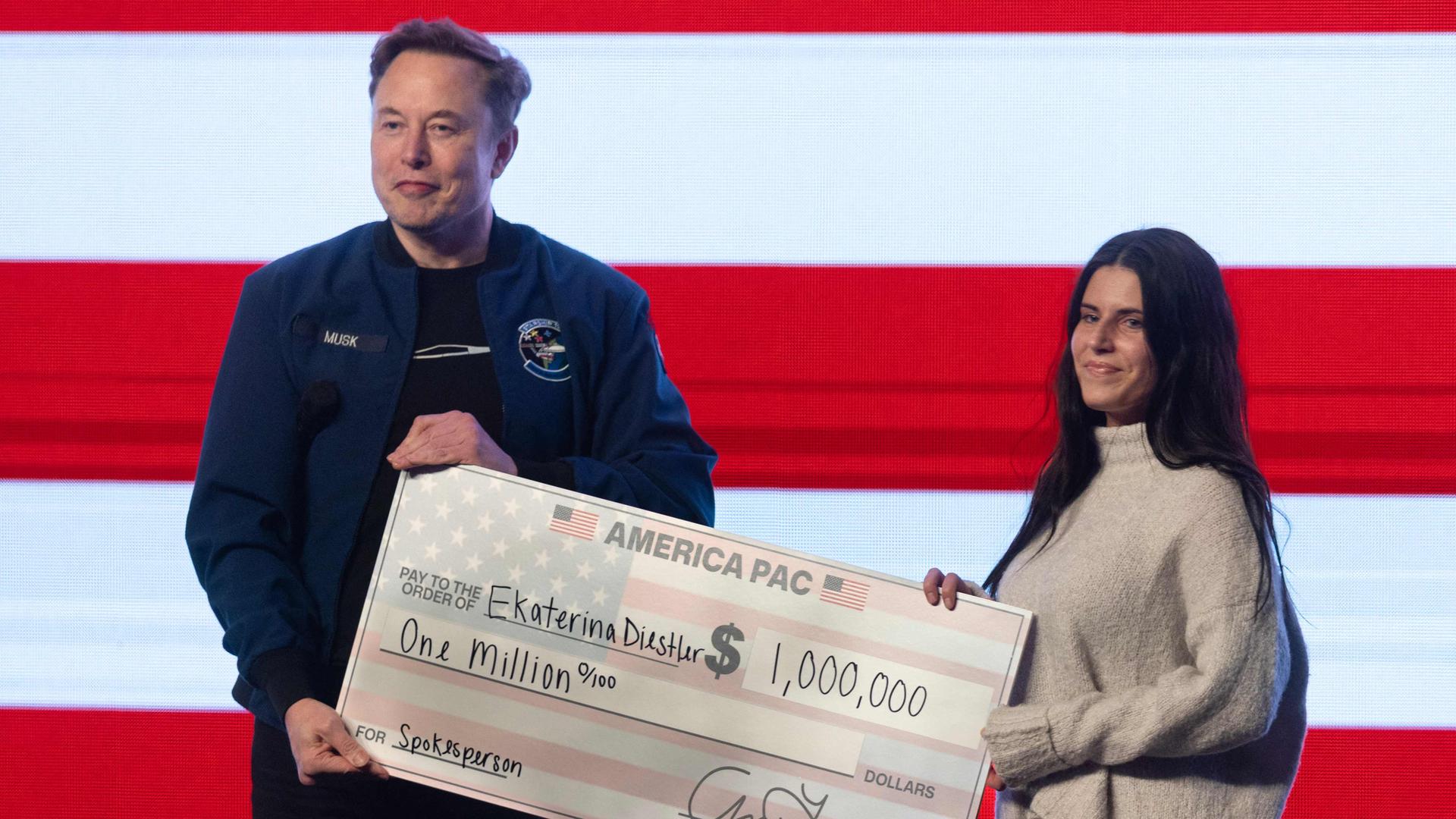 Elon Musk übergibt einen Scheck in Höhe von einer Million Dollar an Frau in Wisconsin
