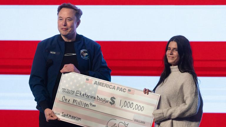 Elon Musk übergibt einen Scheck in Höhe von einer Million Dollar an Frau in Wisconsin