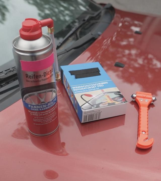 Im Bild sind einige Hilfsmittel rund ums Auto und bei Pannen zu sehen. Von Pannenspray bis Überbrückungskabel. Im Beitrag verraten wir, was man wirklich braucht.     