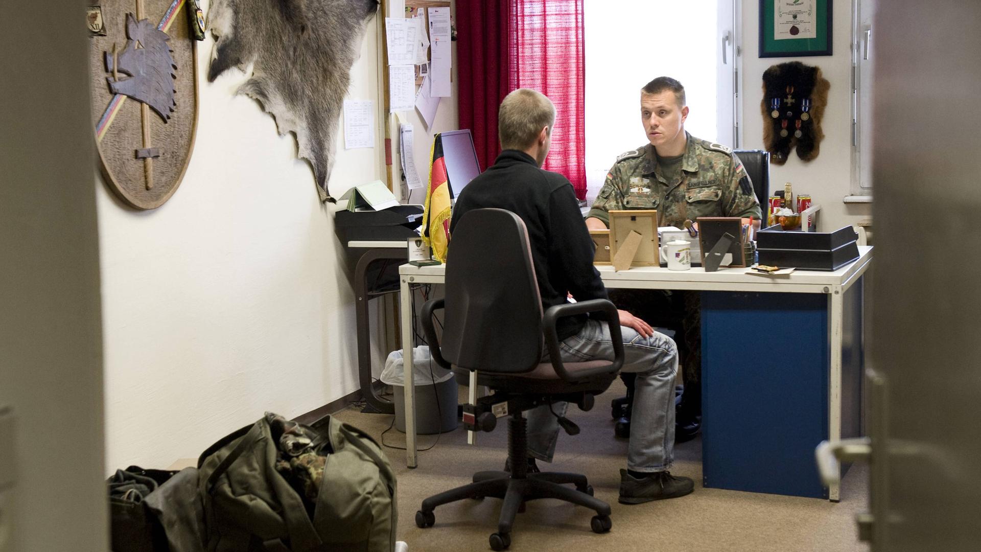 Junger Bewerber erscheint zur Musterung bei Mitarbeitern der Bundeswehr.