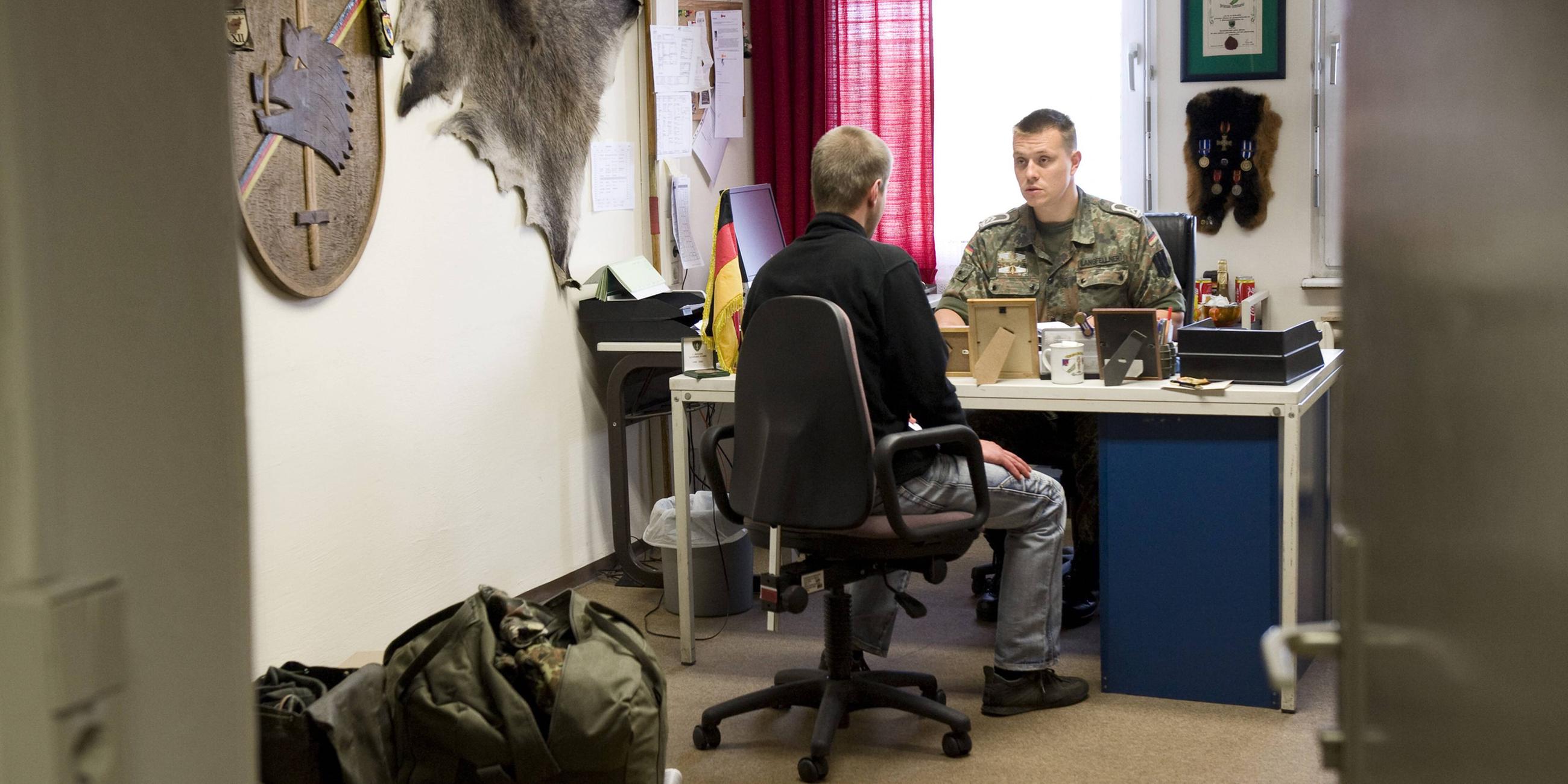 Junger Bewerber erscheint zur Musterung bei Mitarbeitern der Bundeswehr.