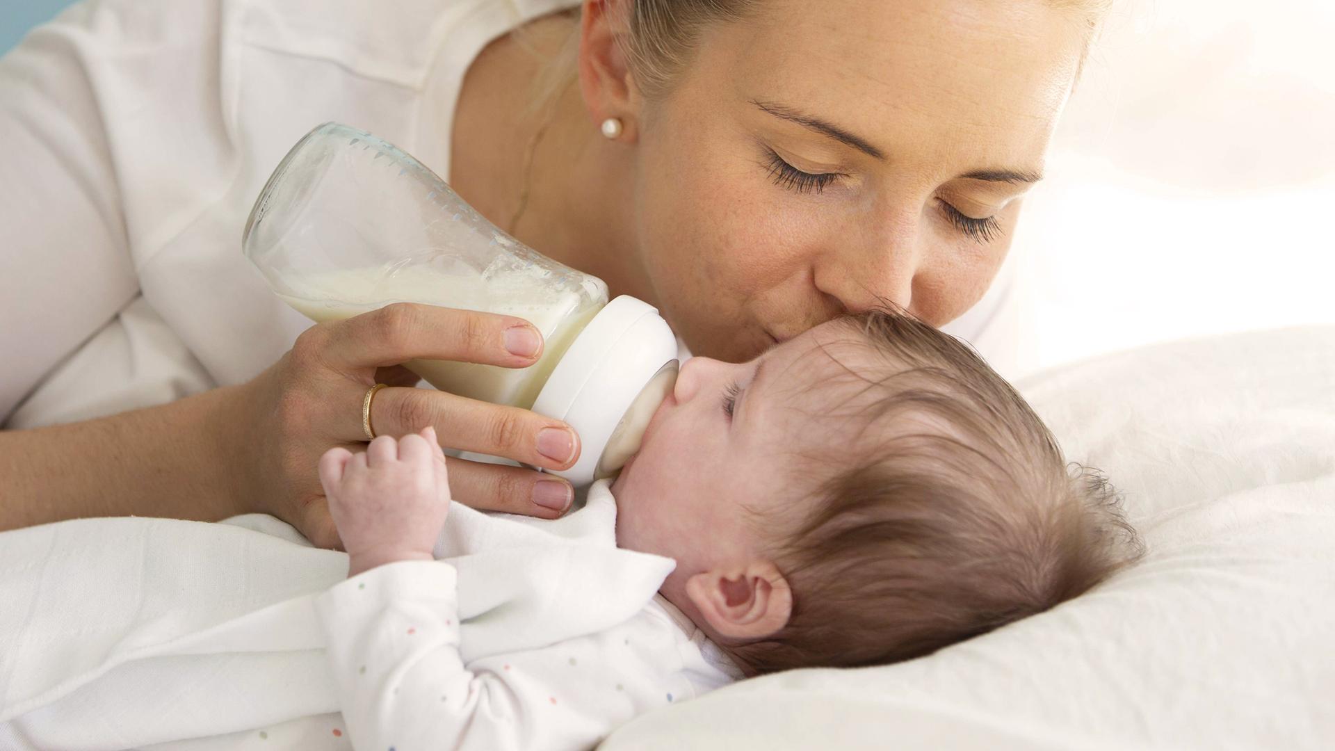Mutter füttert ihr Baby mit einer Flasche.