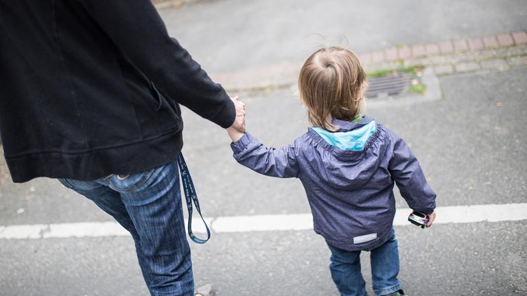 Mutter mit Kind an der Hand