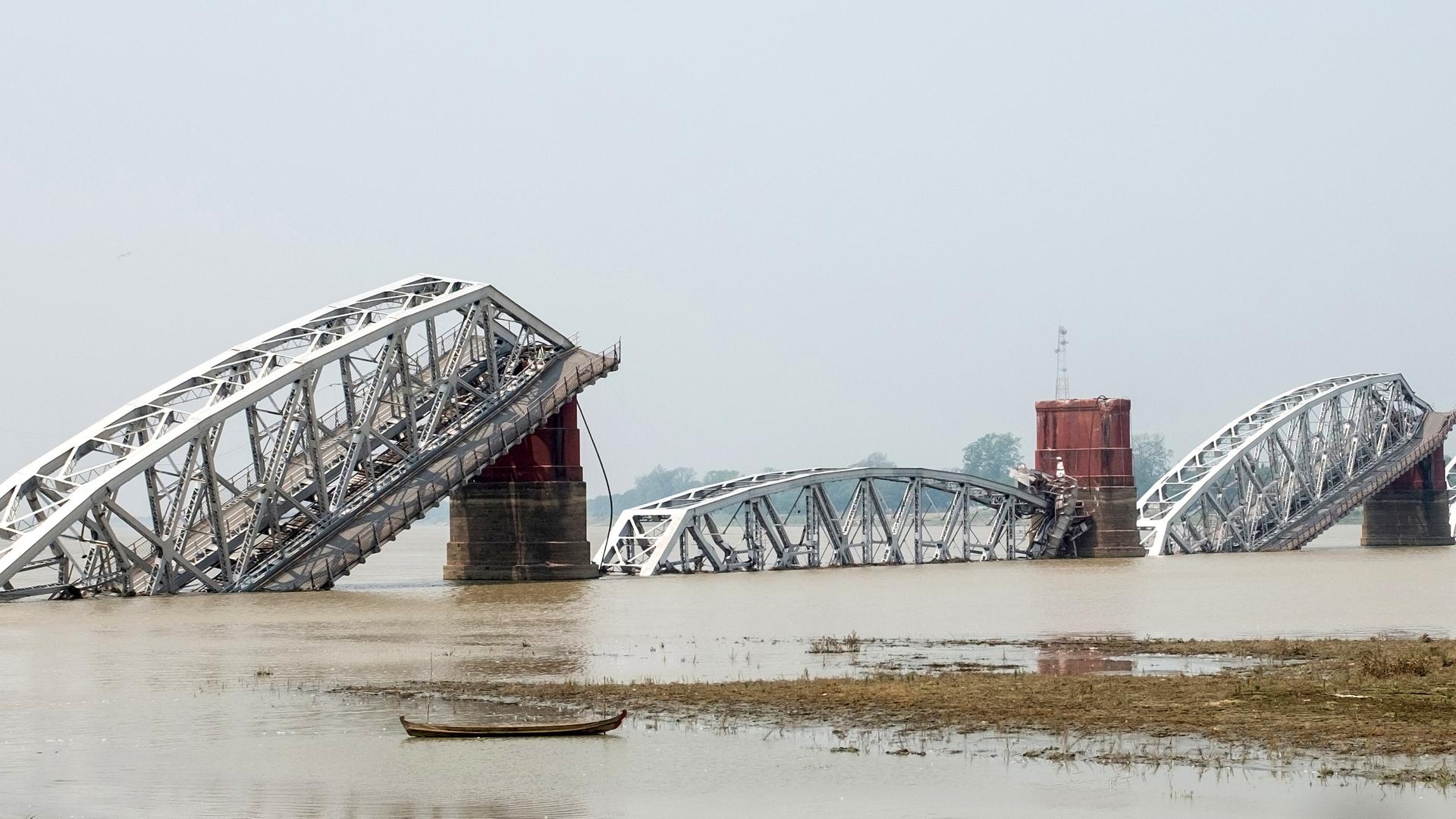 Eine in sich zusammengefallene Brücke über einem Fluss in Myanmar.