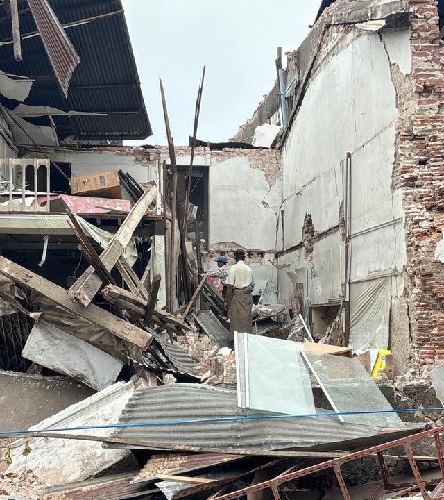 People clean debris from damaged buildings in the aftermath of an earthquake on March 28, in Naypyitaw, Myanmar