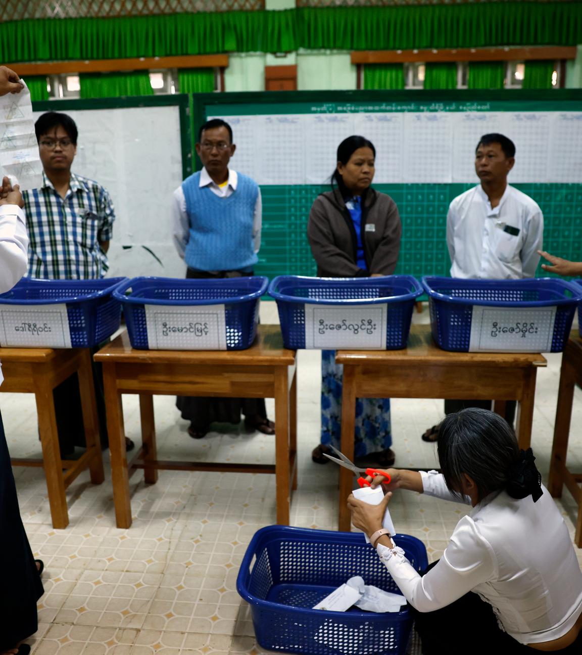 Myanmar electoral officers count early voting ballots after closing the first phase of general election at a polling station