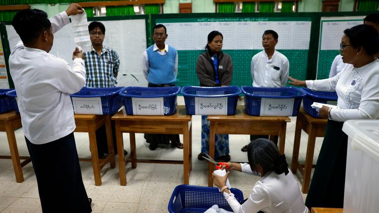 Myanmar electoral officers count early voting ballots after closing the first phase of general election at a polling station