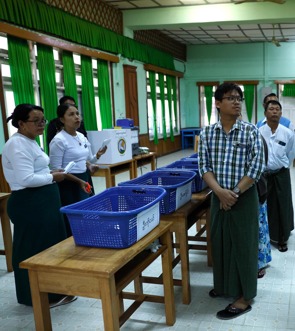 Myanmar electoral officers count early voting ballots after closing the first phase of general election at a polling station