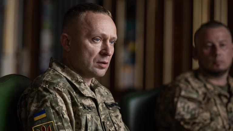 Mychajlo Drapatyj, der neue ukrainische Oberbefehlshaber, sitzt in Armeekleidung im Vordergrund. Im Hintergrund sitzt ein weiterer Mann in Uniform.