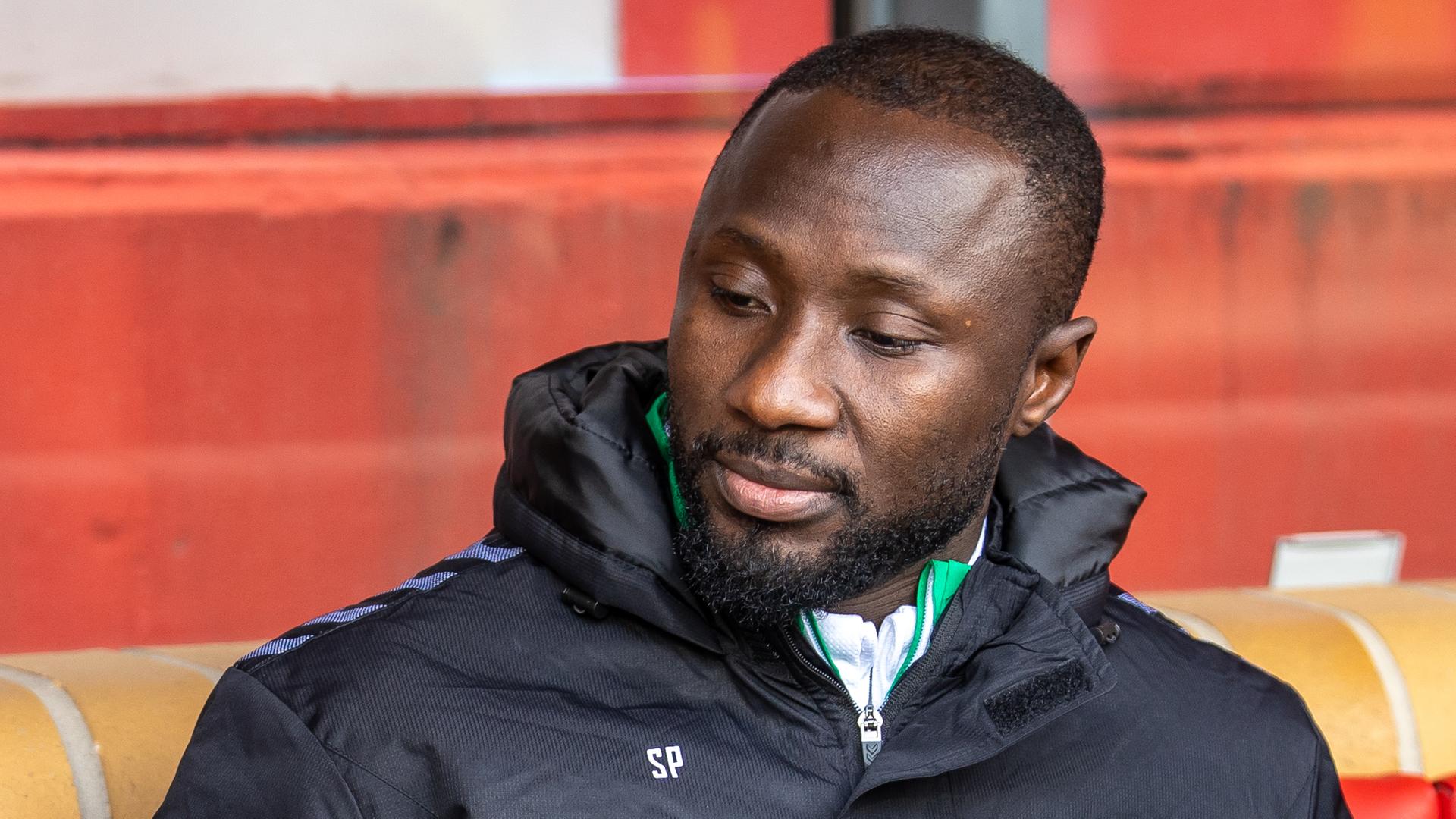 Naby Keita von Werder Bremen sitzt auf der Bank und blickt nach unten. 