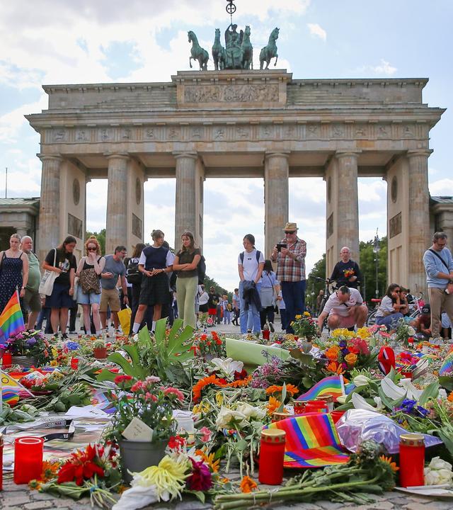 Vor dem Brandenburger Tor haben Menschen in Trauer Blumen abgelegt, um der Opfer des Anschlags auf den Christopher-Street-Day zu gedenke