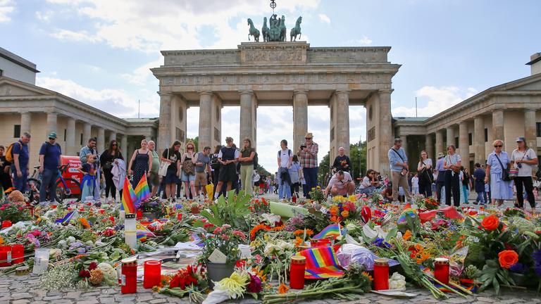 Vor dem Brandenburger Tor haben Menschen in Trauer Blumen abgelegt, um der Opfer des Anschlags auf den Christopher-Street-Day zu gedenke