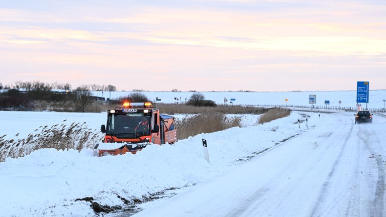 Ein Schneepflug der Kreismeisterei versucht einen Gehweg von den Schneeverwehungen zu befreien.