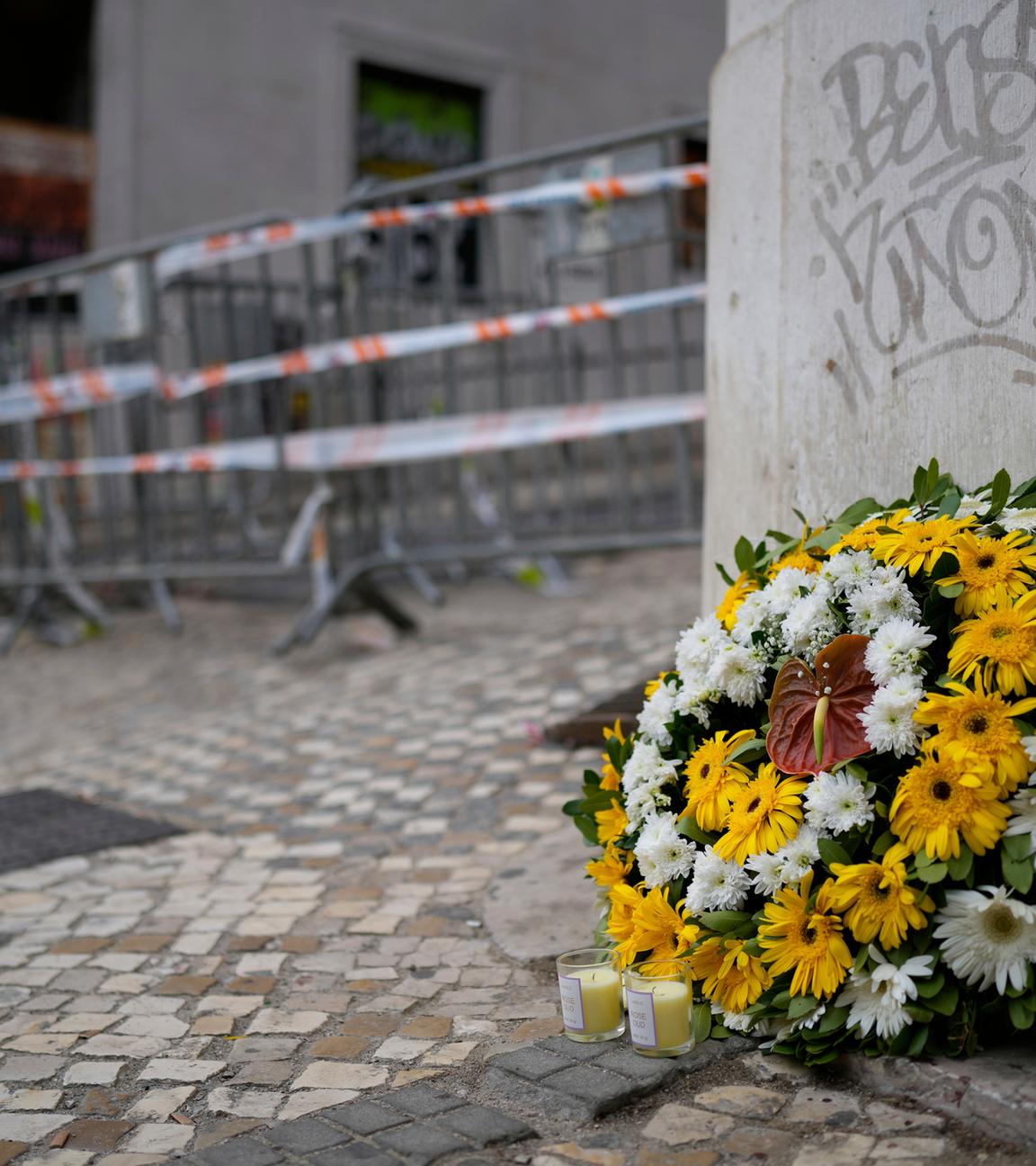 Ein Blumenkranz steht am Unfallort einer entgleisten und verunglückten Standseilbahn. 
