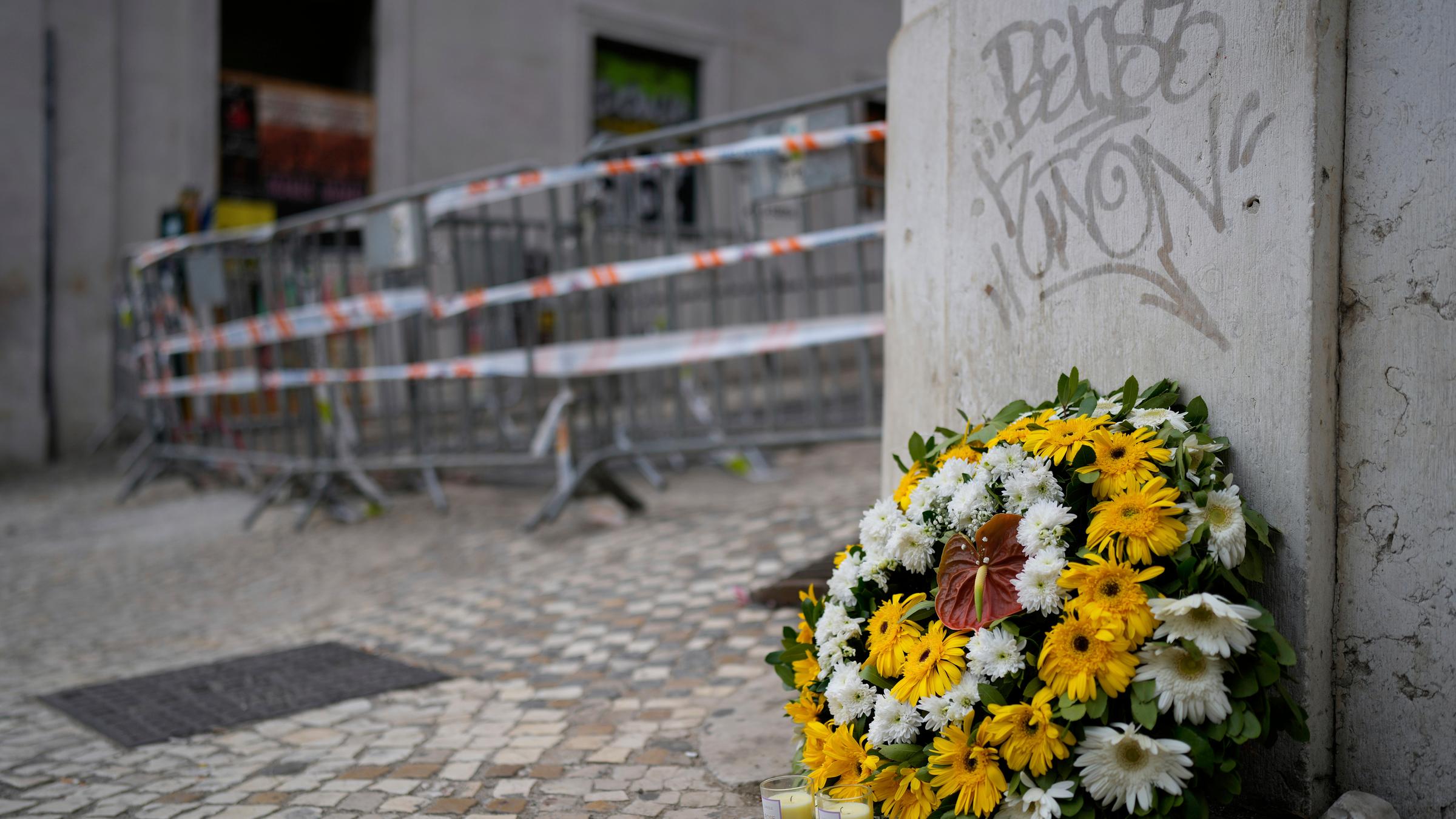 Ein Blumenkranz steht am Unfallort einer entgleisten und verunglückten Standseilbahn. 