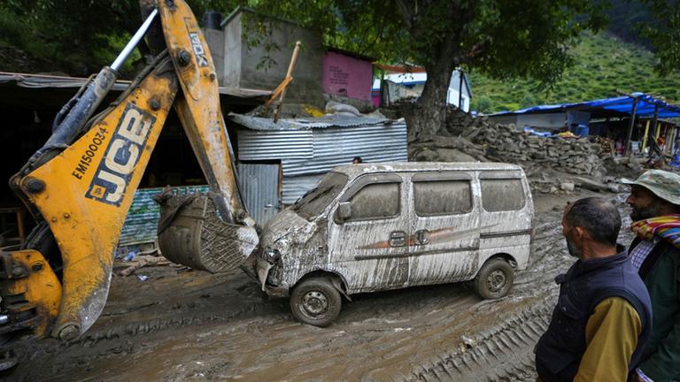 Ein Bagger räumt eine Straße nach den Überschwemmungen in dem Dorf Chositi im Bezirk Kishtwar.