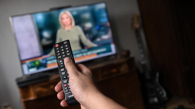 Ein junger Mann sitzt vor dem Fernseher