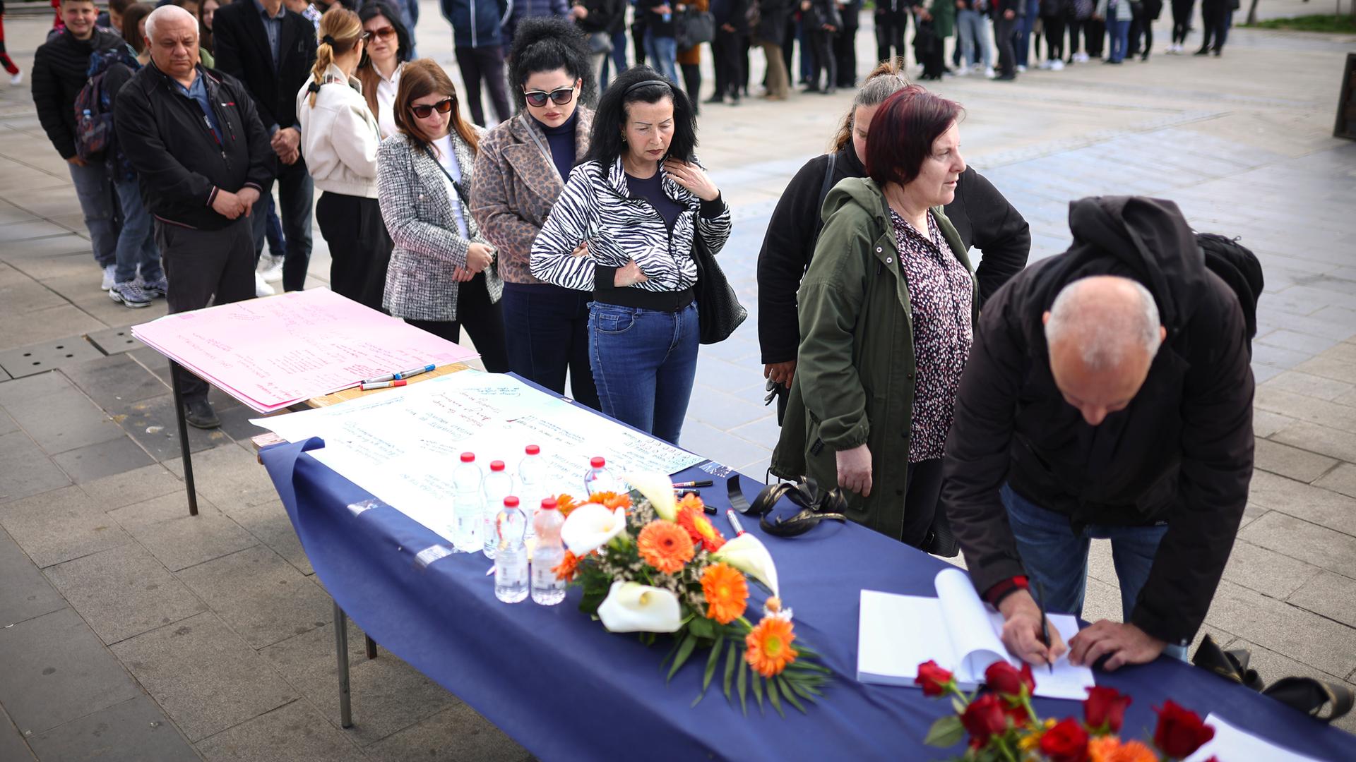 Nordmazedonien, Kocani: Menschen warten in einer Schlange, um Beileidsbekundungen für die Opfer eines massiven Brandes in einem Nachtclub zu schreiben.