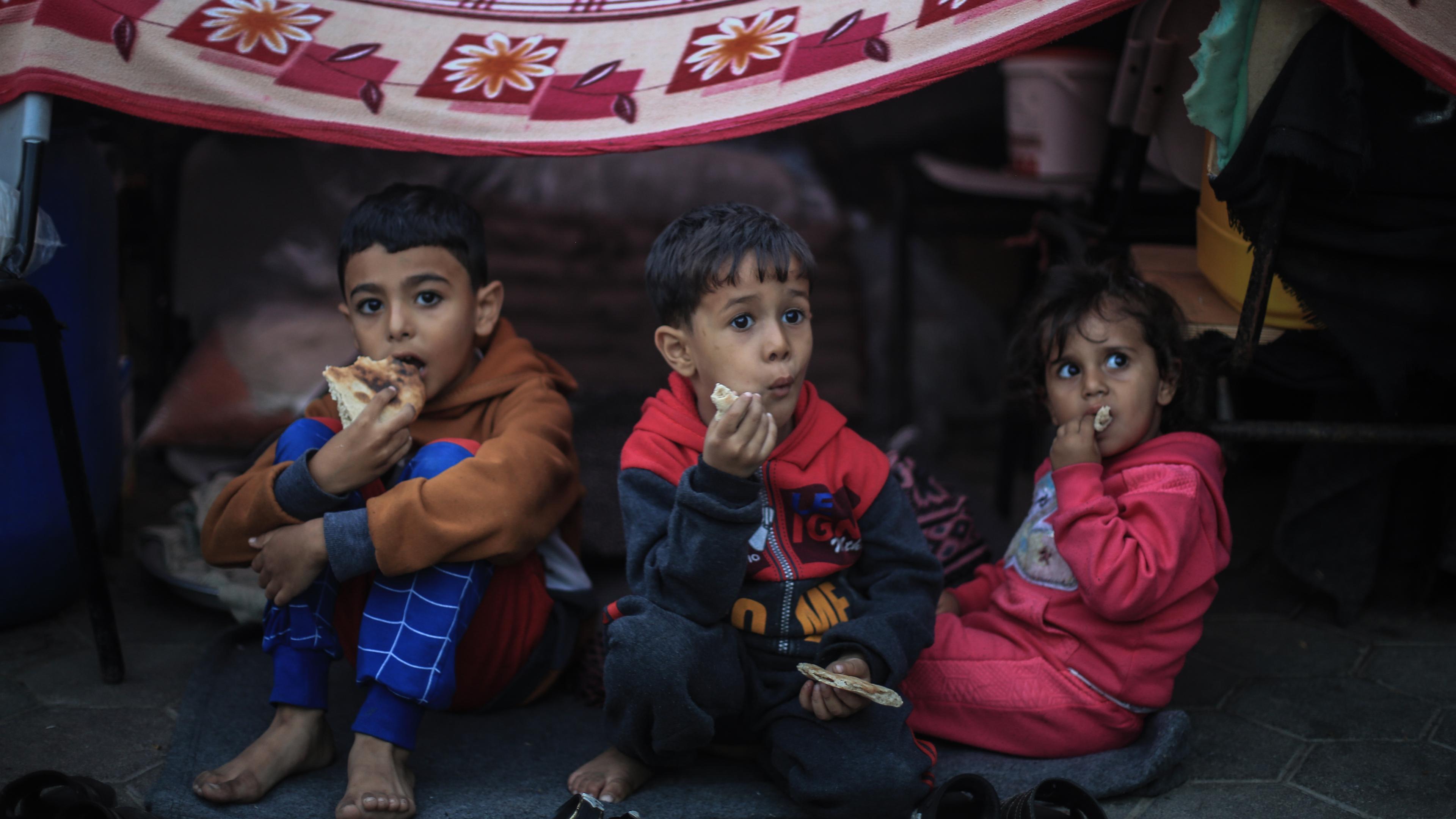 Drei Kinder sitzen in einer Schule in Chan Yunis im südlichen Gazastreifen.