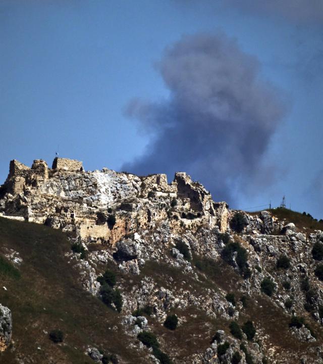 Nach einem israelischen Militärschlag im Südlibanon steigt hinter der Burg Beaufort Rauch in den Himmel auf  aufgenommen aus Nordisrael.