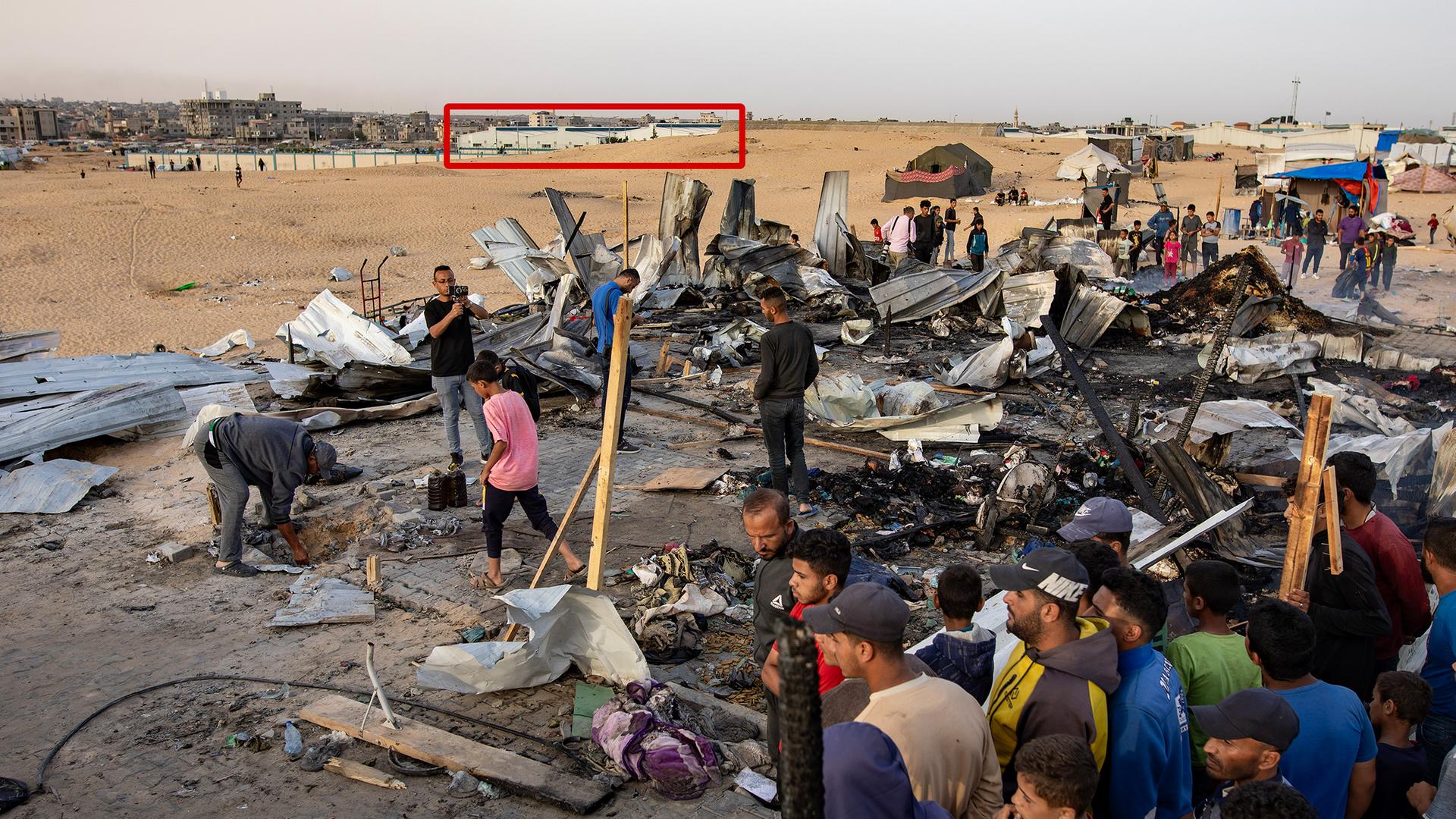 Palästinensische Gebiete, Rafah: Palästinenser inspizieren zerstörte Zelte und Unterkünfte neben einem ausgebrannten Auto nach einem israelischen Luftangriff auf ein Flüchtlingslager.