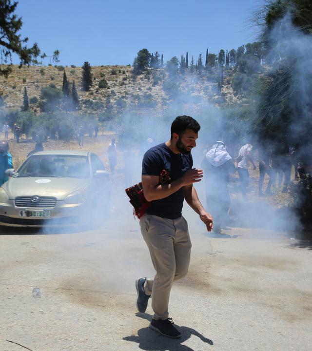 Nahostkonflikt - Westjordanland, Palästinensische Gebiete, Hebron: Ein Mann geht durch Rauch, während sich Palästinenser versammeln, um ihr Land zu verteidigen, nachdem Berichten zufolge Gebiete von Siedlern in Brand gesetzt wurden. 