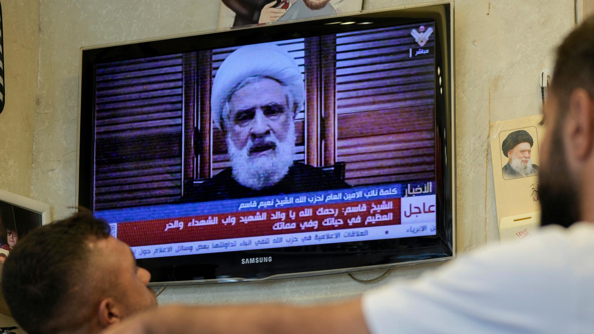 Menschen sehen eine Rede des stellvertretenden Hisbollah-Führers Scheich Naim Kassim, die vom Hisbollah-Fernsehsender al-Manar ausgestrahlt wird