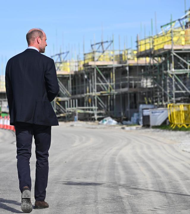 Prinz William läuft eine Straße in Nansledan entlang, vorbei an Baustellen