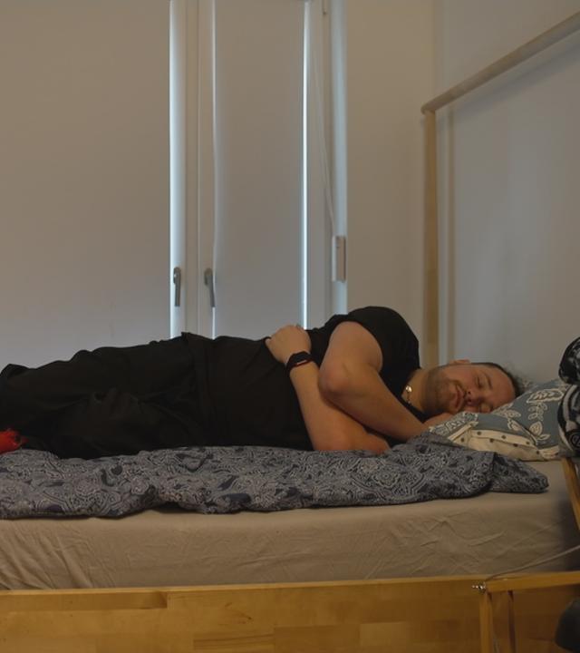 Mann liegt schlafend im Bett