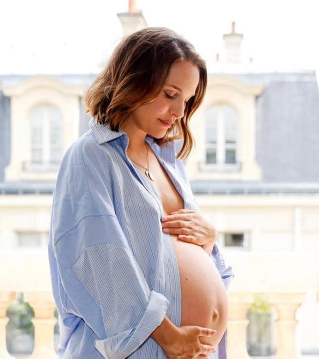 Natalie Portman ist in schwangerem Zustand vor einem Fenster zu sehen.