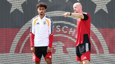 Der deutsche Nationalspieler Nathaniel Brown steht zusammen mit einem Physiotherapeuten auf dem Trainingsplatz in Winston-Salem