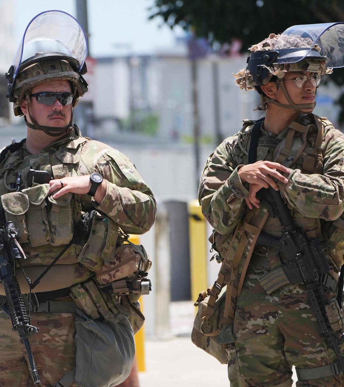 Mitglieder der Californischen National Garde und ein US-Marine bewachen ein Gebäude.