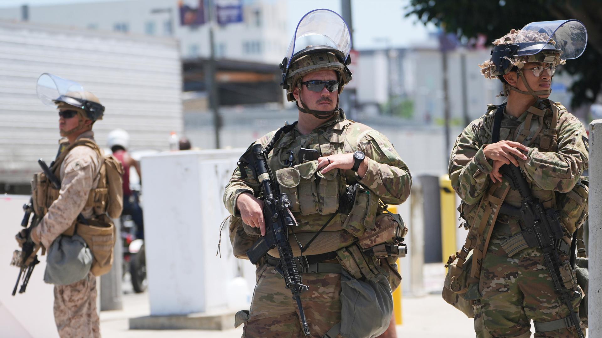 Mitglieder der Californischen National Garde und ein US-Marine bewachen ein Gebäude.