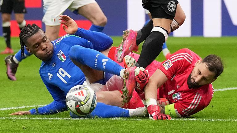 taliens Torhüter Gianluigi Donnarumma kollidiert mit seinem Teamkollegen Destiny Udogie (links), als er einen Schuss von Deutschlands Joshua Kimmich abwehrt und über ihn springt