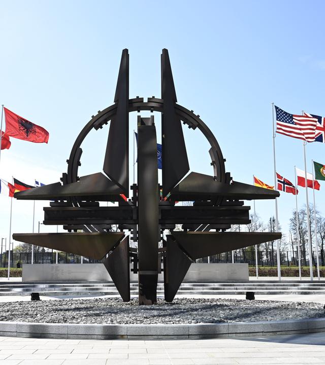 Das Nato-Symbol steht im Zentrum mit allen Flaggen der Mitgliedsnationen ringsum aufgestellt.