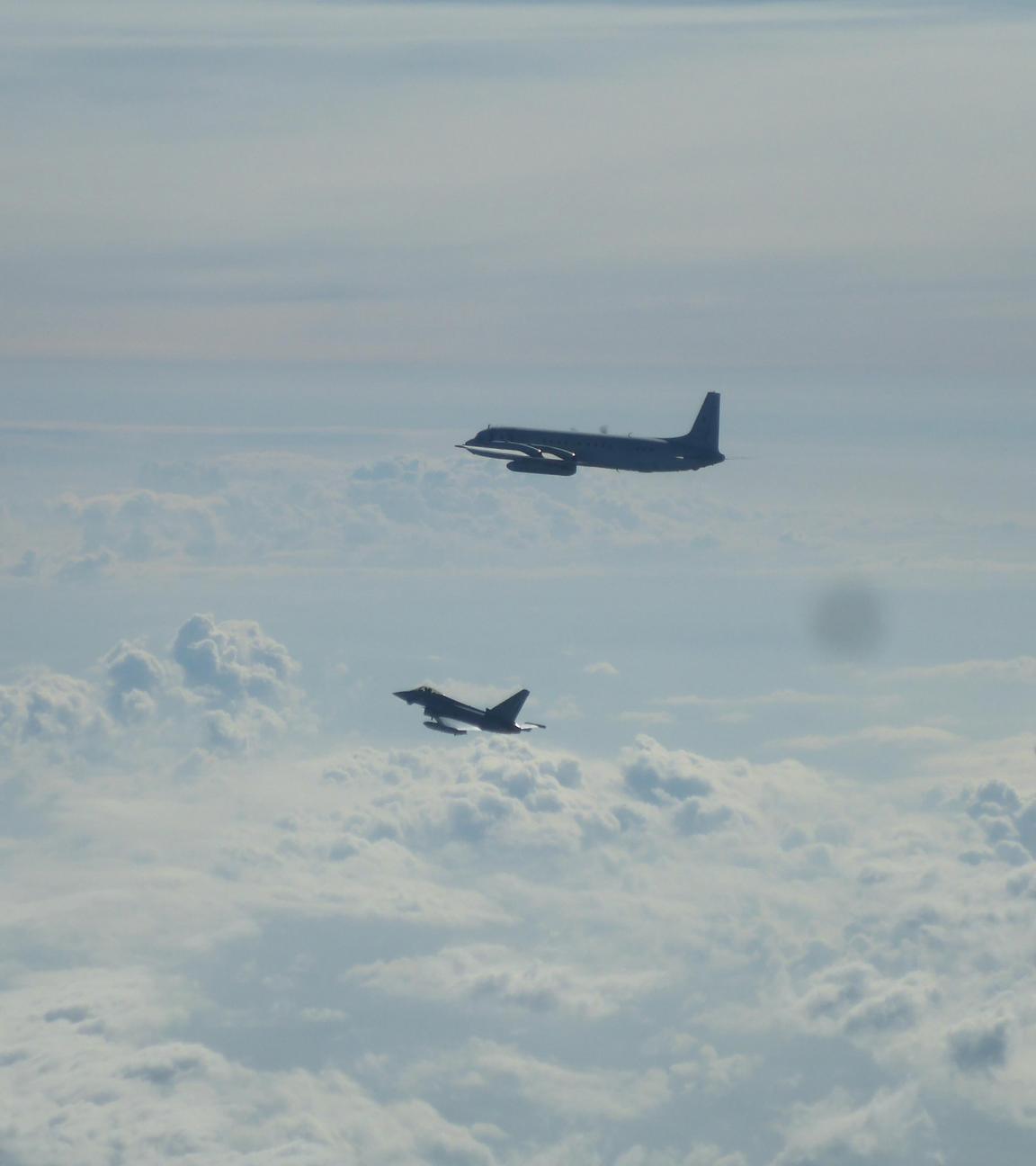 Ein Eurofighter (unten) und ein russisches Flugzeug Il-20M fliegen über der Ostsee. 