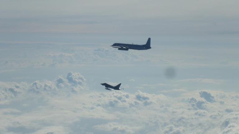 Ein Eurofighter (unten) und ein russisches Flugzeug Il-20M fliegen über der Ostsee. 