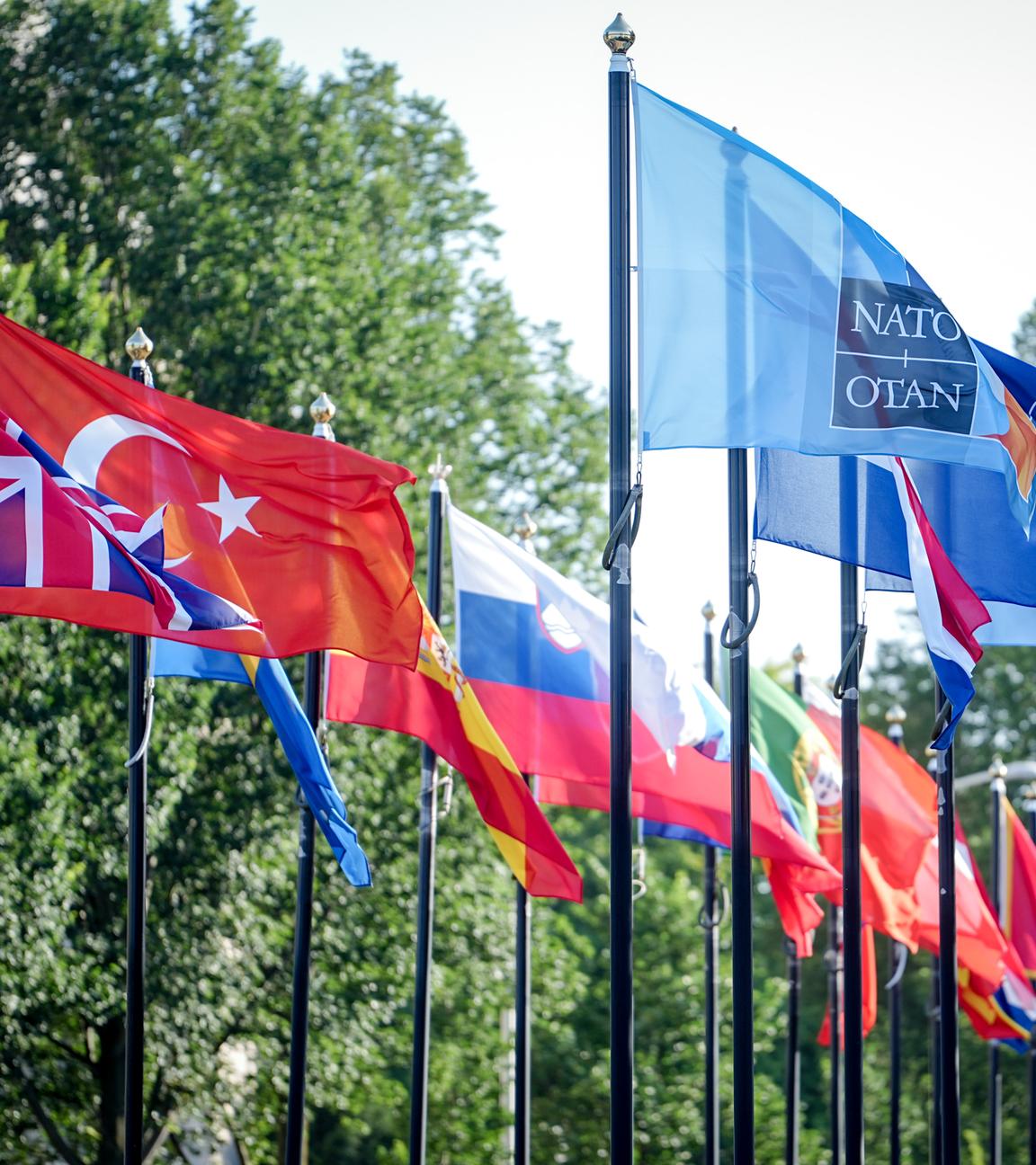 Flaggen wehen auf dem Gelände des NATO Gipfels im Wind.