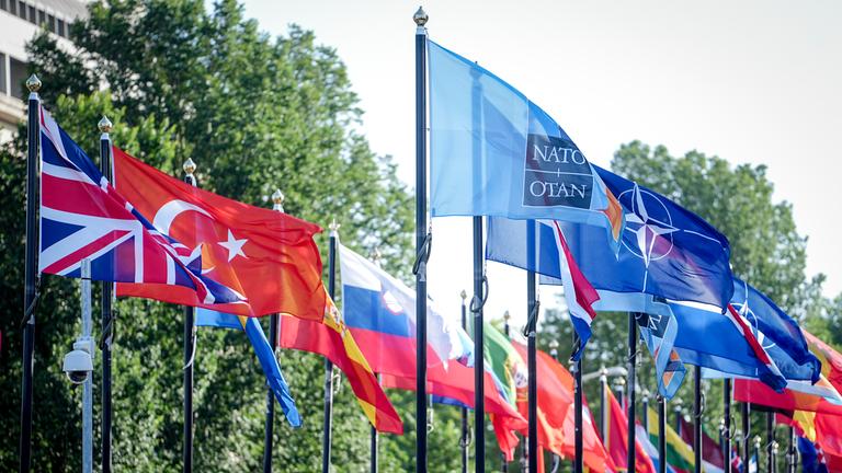 Flaggen wehen auf dem Gelände des NATO Gipfels im Wind.