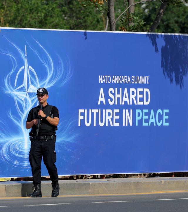 Türkei: Ankara: Ein Polizist patrouilliert vor einem Nato-Gipfel-Transparent.