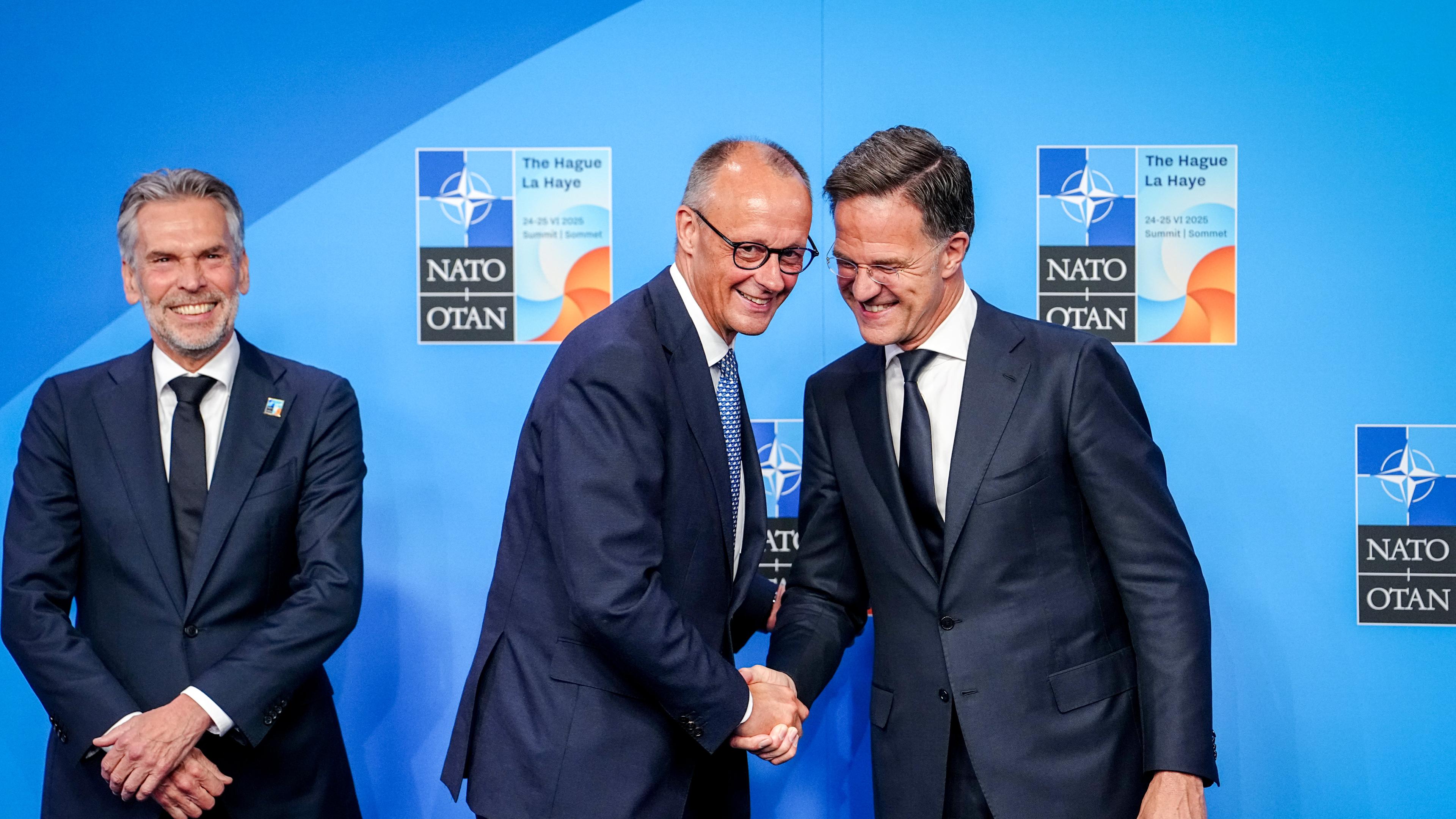 Bundeskanzler Friedrich Merz (M, CDU) wird von Mark Rutte (r), Generalsekretär der Nato, und Dick Schoof, Ministerpräsident der Niederlande, beim Nato-Gipfel empfangen.