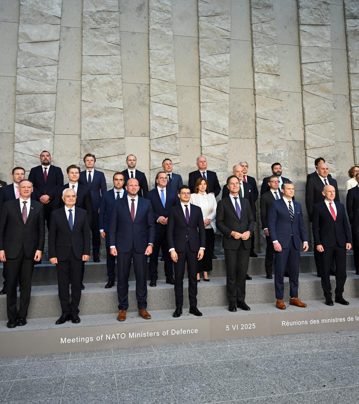 NATO-Verteidungsminister in drei Reihen neben- und hintereinander aufgestellt.
