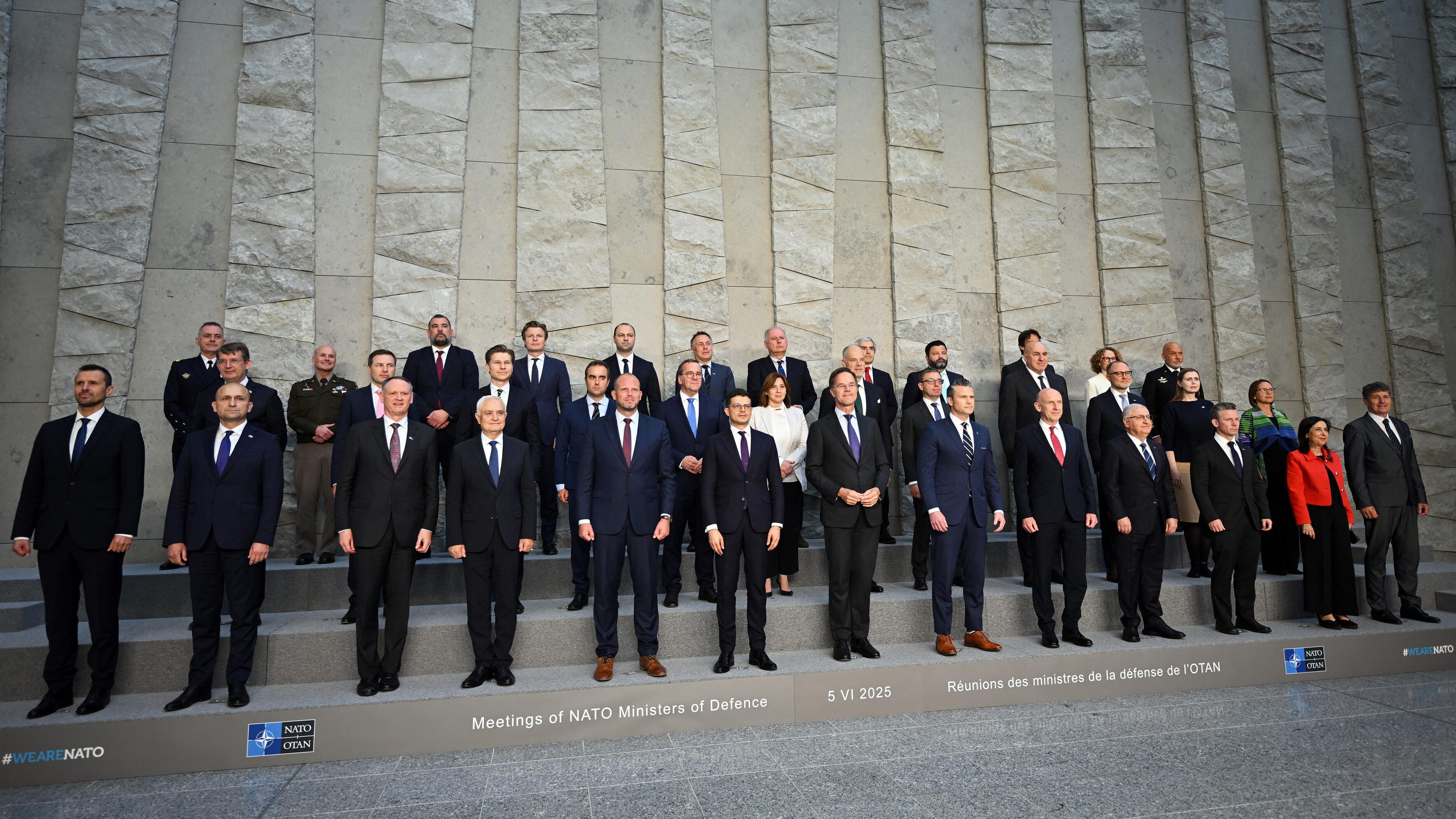 NATO-Verteidungsminister in drei Reihen neben- und hintereinander aufgestellt.