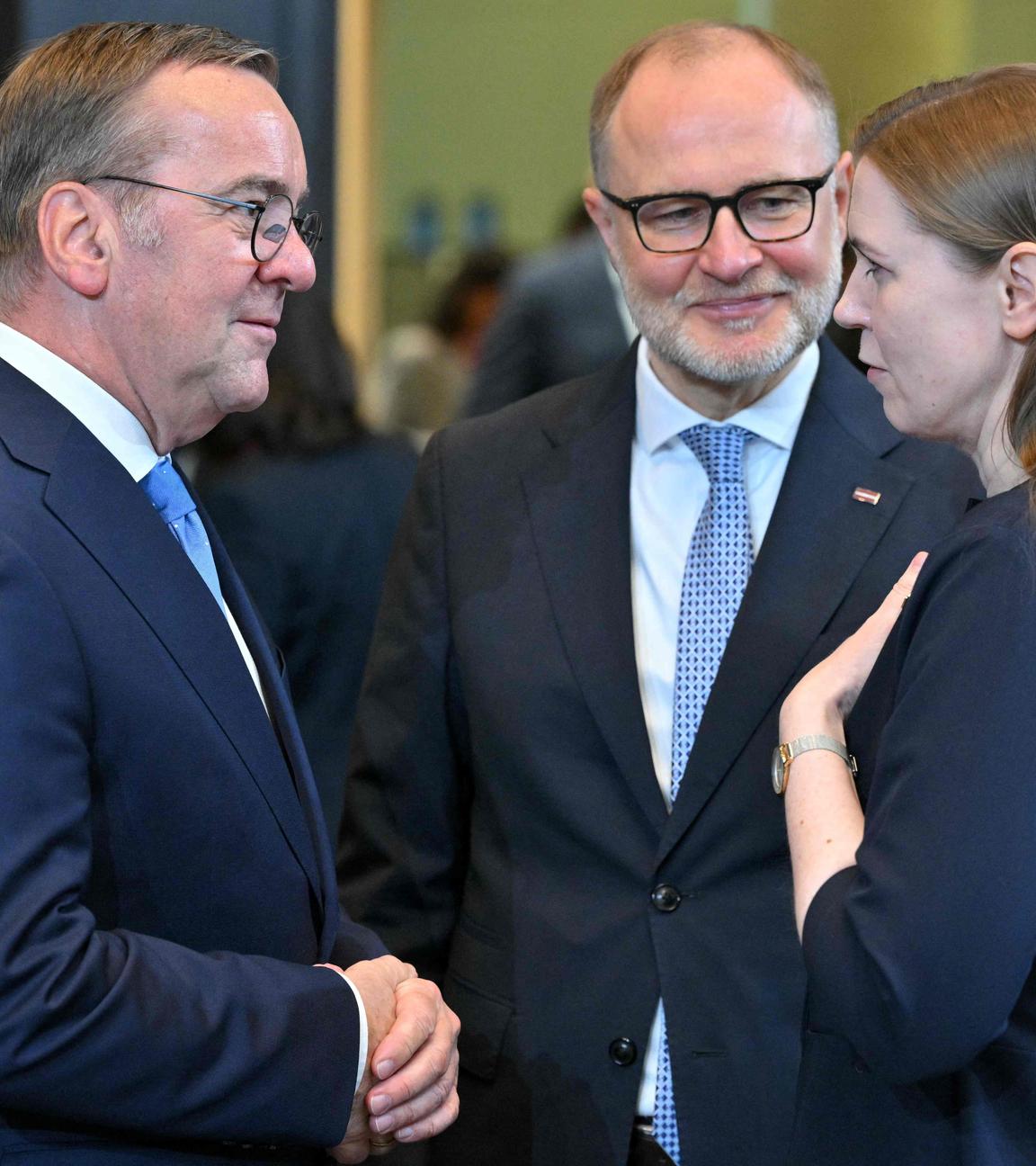 Verteidungsminister Pistorius unterhält sich mit Litauens Verteidungsministerin Sakaliene, ein anderer Mann steht zwischen ihnen einen Schritt weiter hinten.
