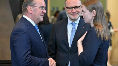 Verteidungsminister Pistorius unterhält sich mit Litauens Verteidungsministerin Sakaliene, ein anderer Mann steht zwischen ihnen einen Schritt weiter hinten.