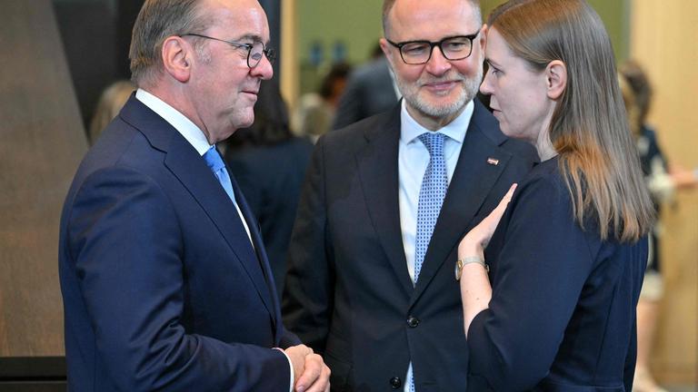 Verteidungsminister Pistorius unterhält sich mit Litauens Verteidungsministerin Sakaliene, ein anderer Mann steht zwischen ihnen einen Schritt weiter hinten.