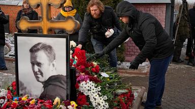 Menschen legen ein Jahr nach dem Tod des russischen Oppositionsführers Alexej Nawalny auf dem Borisowskoje-Friedhof in Moskau Blumen an seinem Grab nieder.