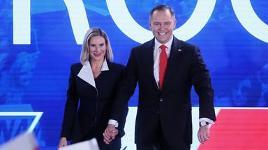 Nawrocki, der die Präsidentschaftswahlgewonnen hat mit seiner Frau. Sie halten sich an der Hand und lachen.