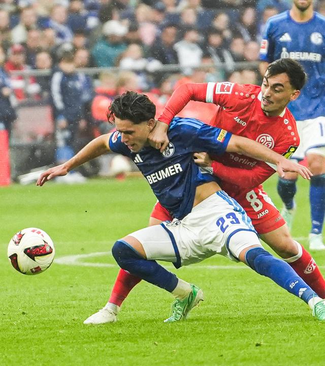 Der Mainzer Offensivspieler Paul Nebel reißt im Zweikampf seinen Schalker Gegenspieler Soufiane El-Faouzi zu Boden 